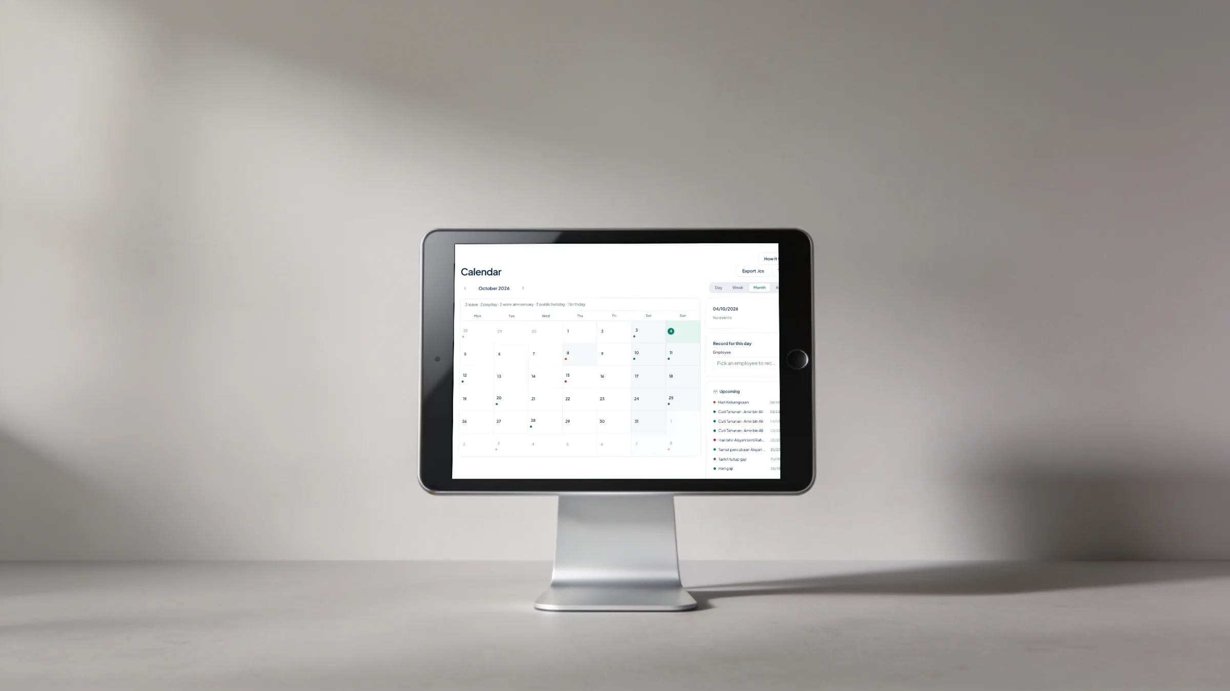 A tablet on a stand showing the Orbit HR calendar for October 2026 with leave, paydays, public holidays and work anniversaries
